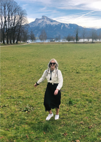 Reagan standing in a green field in front of snowcapped mountains